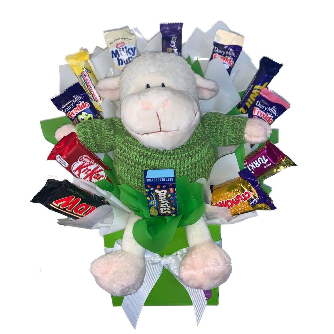 25cm Plush lamb wearing a green sweater surround by Nestle, Cadbury and Mars chocolates sitting in a posy box by Lollylicious