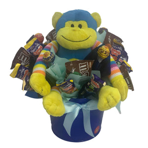 Blue Monkey in a metal tin surrounded by chocolate and lollies